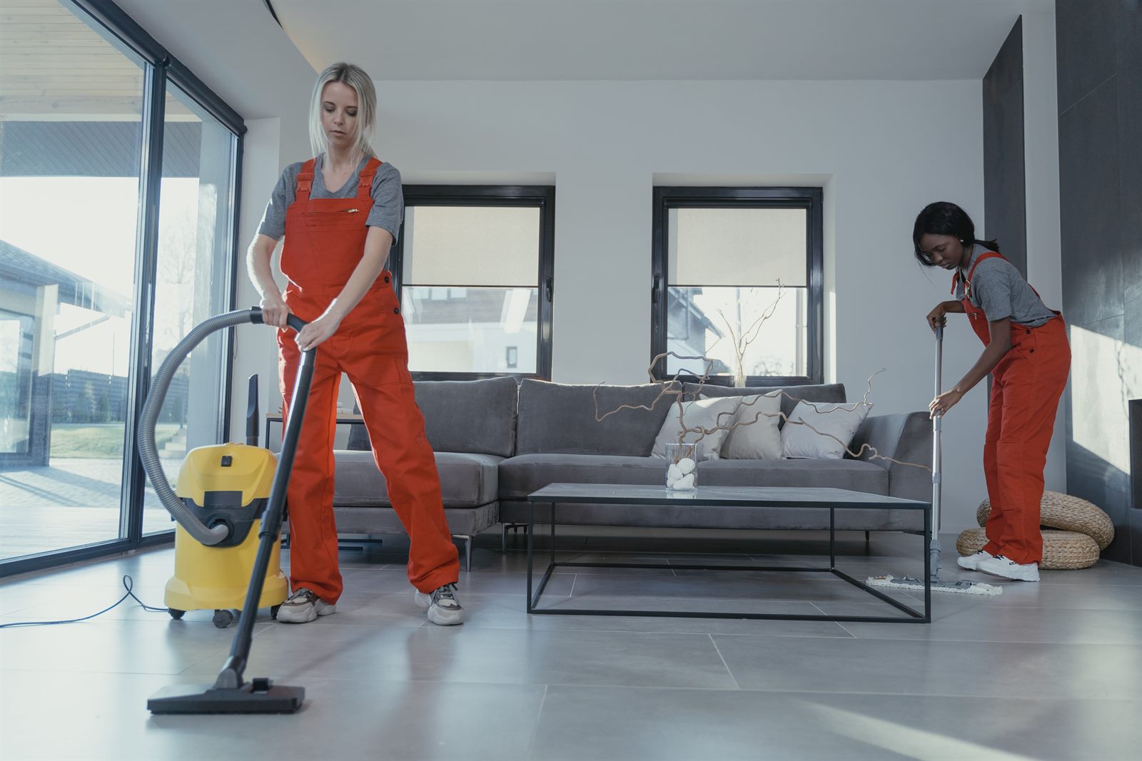 M-Pac Cleaning team vacuuming and mopping a living room during a turnover clean in Greater Boston